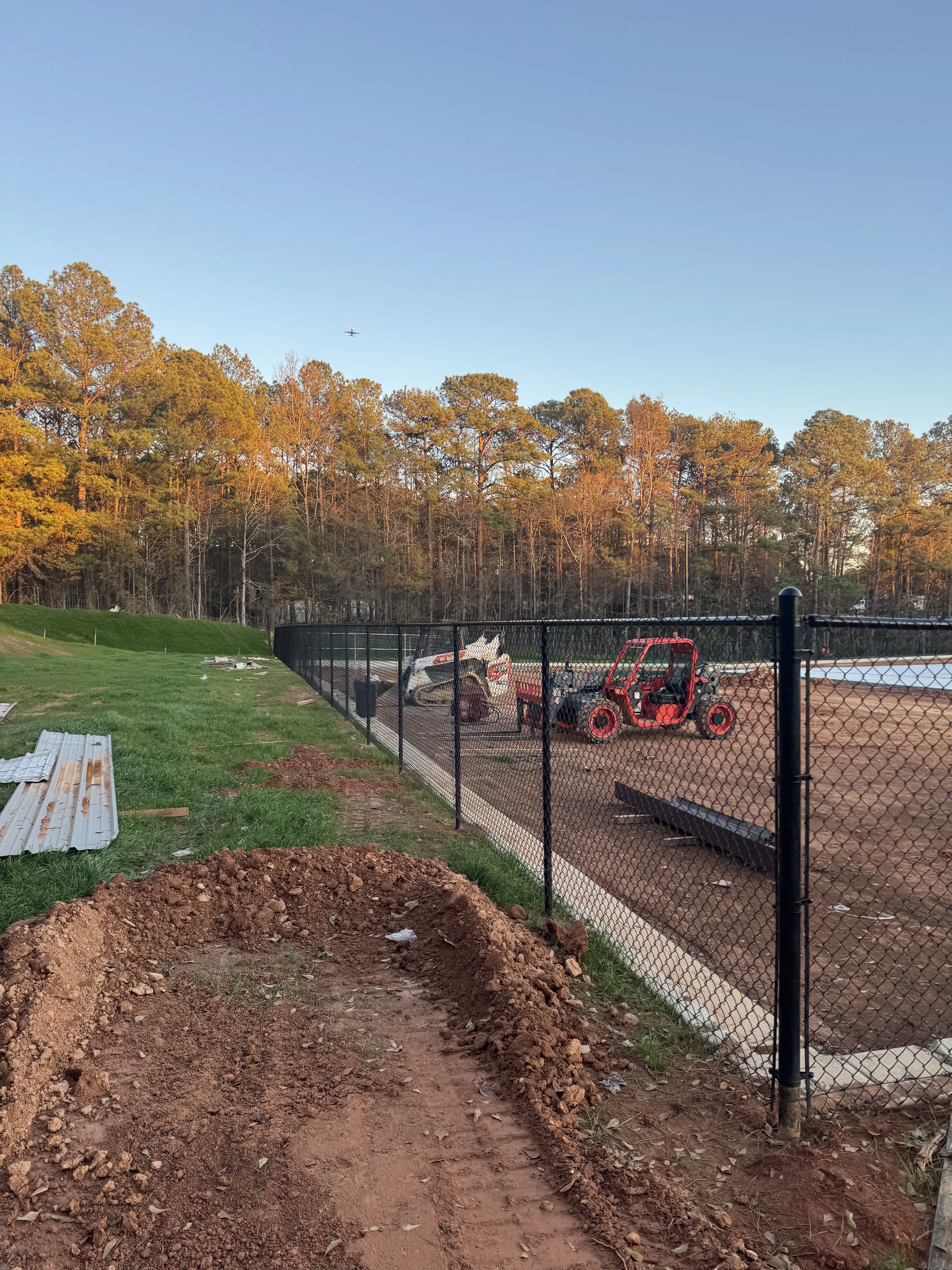 Chain link fence installation with autumn foliage