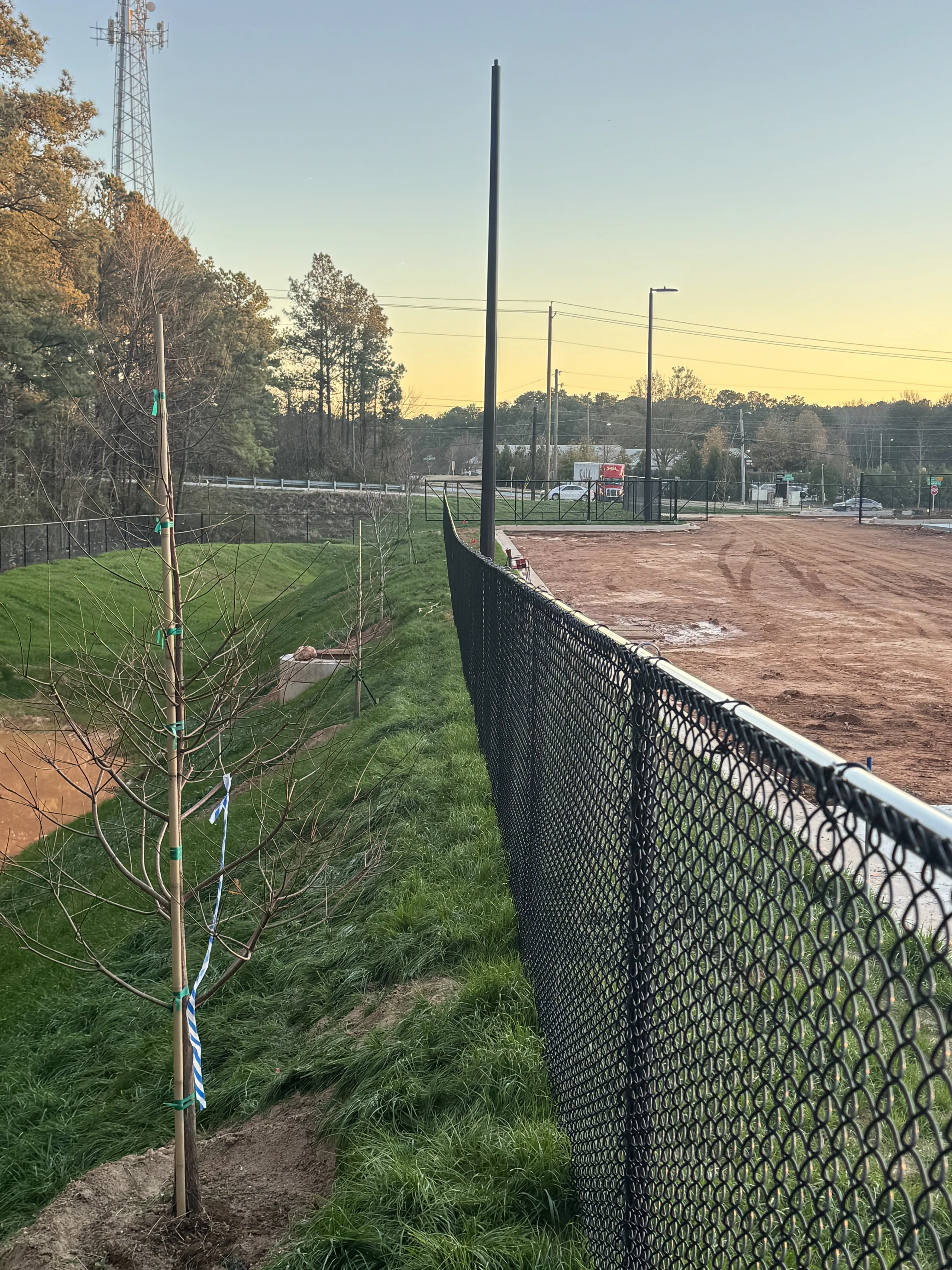 Chain link fence corner post at sunset