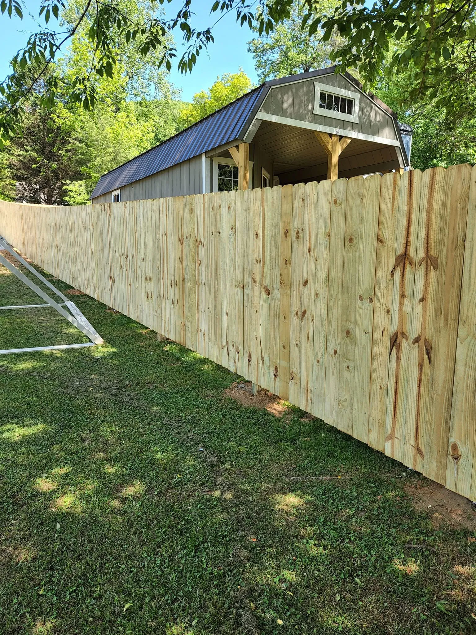 Wood privacy fence along barn