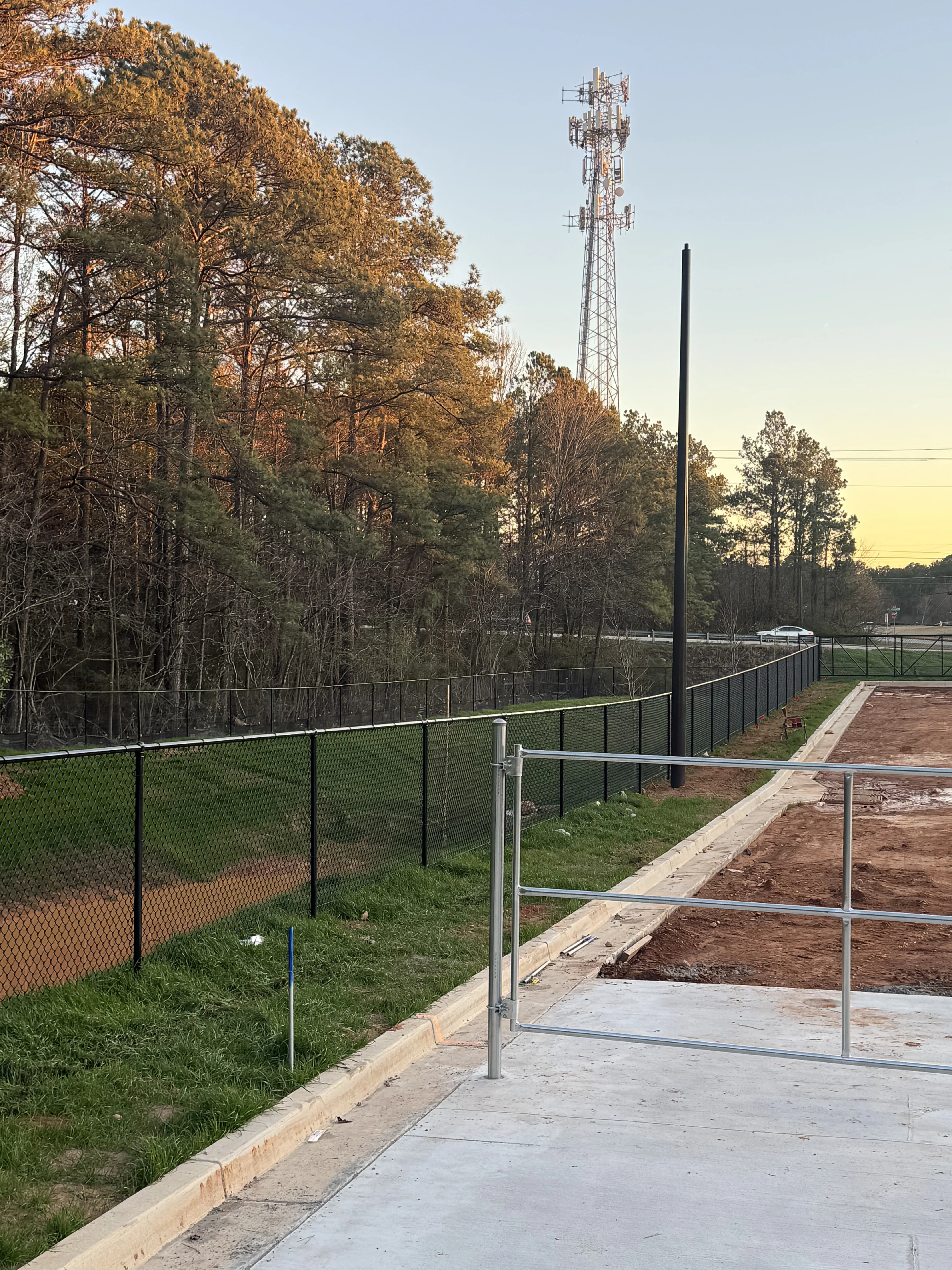 Chain link fence along commercial building at sunset
