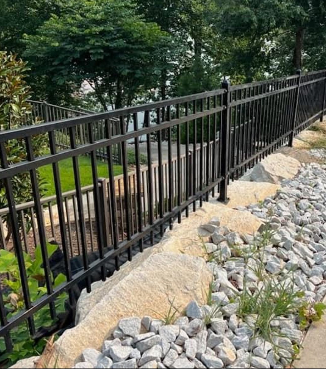 Ornamental iron fence with rock landscaping
