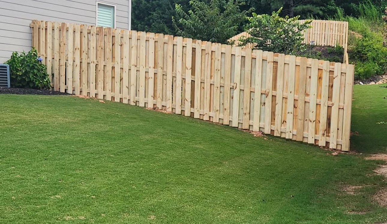Wood shadow box fence on green lawn